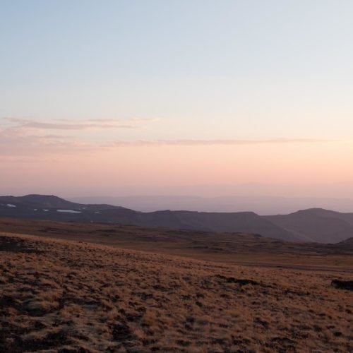 The last fence in Steens Mountain Wilderness is pulled beneath a pink sky.