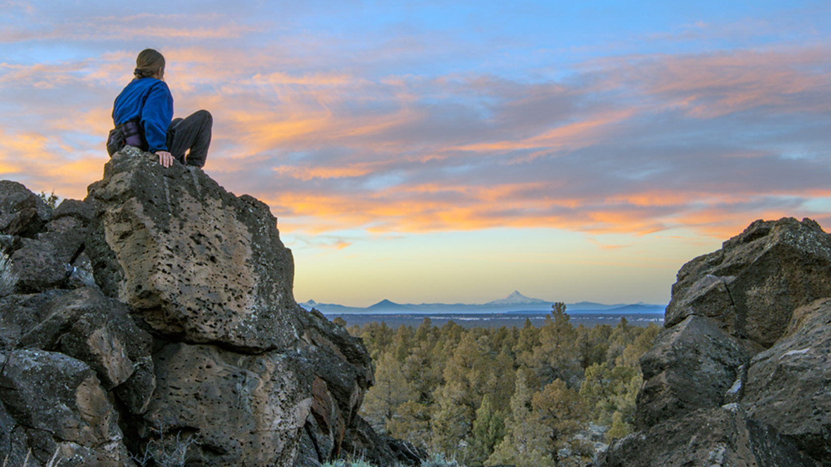 A hiker admires sunset in the Badlands Wilderness