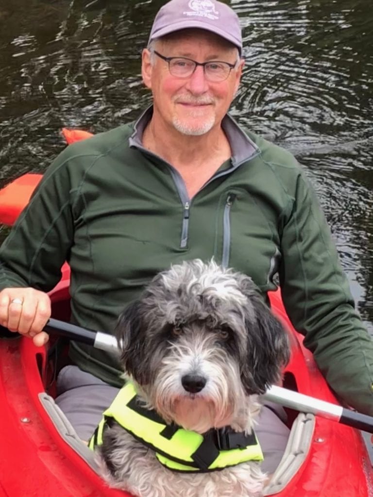 kayaker in red kayak with dog