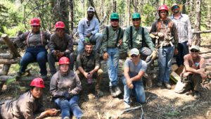 Tribal Stewards crew poses with Forest Service staff in front of newly built fence at Little Crane Creek
