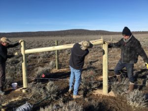 Volunteers build an h-brace at the Brothers fence build